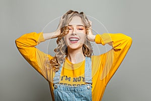 Real happy young woman smiling on gray background