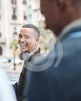 Real life young man portrait in the street with headphones, enjoying music on a playlist app looking happy, stressless