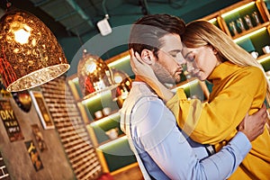 Real love. Young man holding pretty blonde woman in his hands, close-up