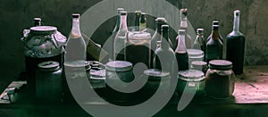 Dusty old glass bottles and cans with suspicious content