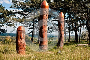 Real pagan altar in the forest with idols in summer light.