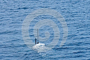 Real periscope and radio transmission mast of the attack submarine  during the submarine sails in the periscope depth in the sea photo