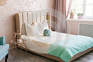 Real photo of a feminine bedroom interior with a comfy armchair, bed