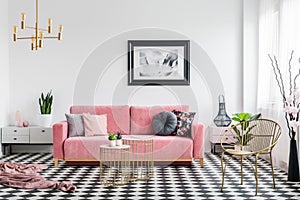Real photo of a glamor living room interior with a powder pink s
