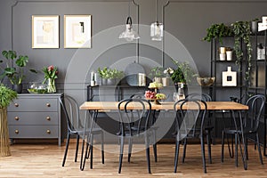 Real photo of a gray and black dining room interior with posters photo