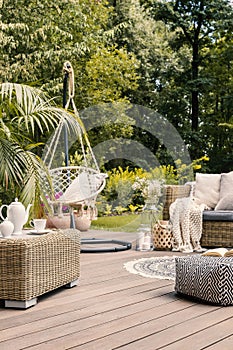 Real photo of a hanging chair and rattan furniture on a wooden t