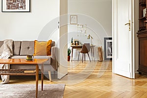 Real photo of a retro living room interior and view of a home office. View through a door