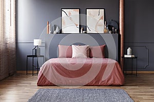 Real photo of a simple bedroom interior with dirty pink bedding