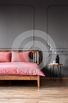 Real photo of a simple and elegant bed with dirty pink bedding n