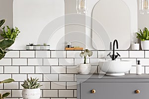 Real photo of a washbasin on a cupboard in a bathroom interior w