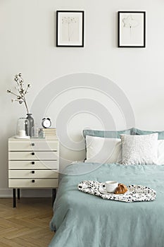 Real photo of white bedroom interior with breakfast placed on be