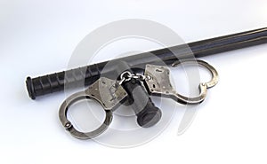 Real police handcuffs and baton isolated on white background
