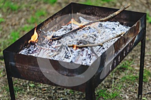 Real portable BBQ grill on background of a fresh green summer la