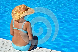 Real pregnant female beauty relaxing at swimming pool