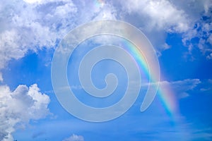 Real rainbow on blue sky with clouds nature background.
