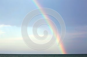 Real rainbow after the storm over the ocean and the blue sky