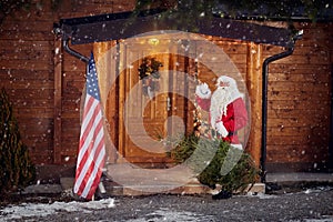 Real Santa Claus front his wooden house