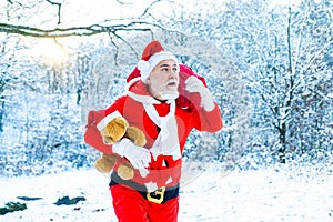 Real Santa Claus in red cap pulling large red gift sack. Christmas Celebration holiday. Merry Christmas and Happy New