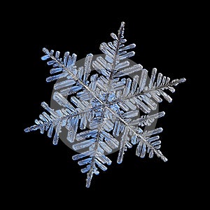 Real snowflake isolated on black background