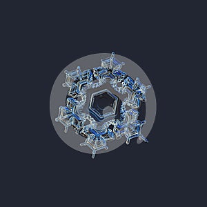 Real snowflake isolated on uniform blue background