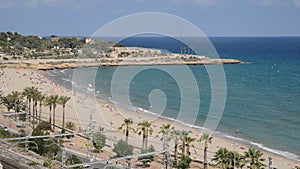 Real time of unidentifiable sunbathers at Miracle Beach in Tarragona, Spain on the idyllic Costa Daurada meaning Golden