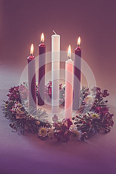 Real traditional christian religious advent wreath with 5 candles, 4 candles burning