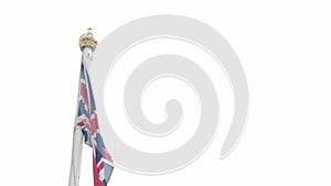 Real Union Jack flag of the United Kingdom on flagpole fluttering in the wind