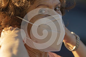 A real woman shows how to put on the protective mask to prevent the spread of the COVID-19 photo