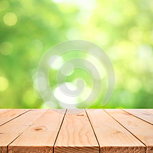 Real wood table top texture on blur leaf tree garden background.For create product display or design key visua