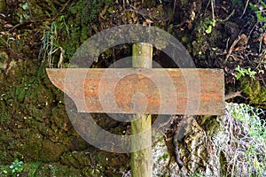Real wooden blank signpost with a dirt and rocks background photo