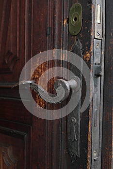 Real wooden door with a hand-wrought iron handle. Wood with iron for background. A wooden texture with an iron lock of old times.