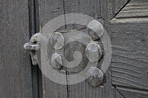 Real wooden texture with a hand-wrought iron element. Wood with iron background. A wooden door with an iron lock of old times. Old