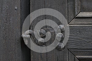 Real wooden texture with a hand-wrought iron element. Wood with iron background. A wooden door with an iron lock of old times. Old