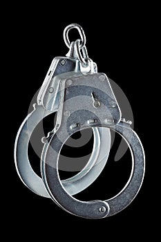 real zinc plated steel police handcuffs closed, isolated on black background
