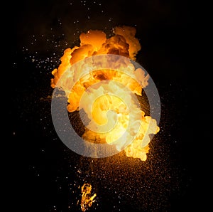 Realistic fiery explosion with sparks over a black background