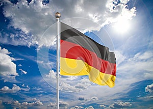 Realistic flag. 3D illustration. Colored waving flag of Germany on sunny blue sky background