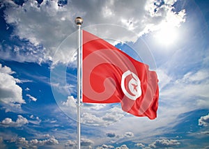 Realistic flag. 3D illustration. Colored waving flag of Tunisia on sunny blue sky background