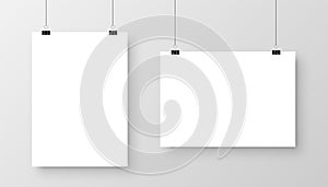 Realistic hanging blank paper sheet with shadow in A4 format and black paper clip, binder on gray background. Design