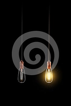 Realistic light bulb. Retro light. Turned off and glowing yellow incandescent lamp. Light background. Isolated in black