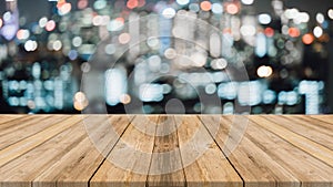 Realistic wooden board empty table in front of blurred background. Night lights bokeh on blur restaurant background