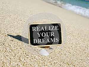 Realize your dreams written on a wooden plate