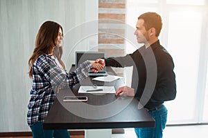 Realtor, broker or landlord shows an apartment to a young woman. She is going to sign a lease agreement with him. Estate