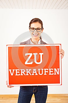 Realtor In Empty Apartment, Holding `zu Verkaufen` Sign photo