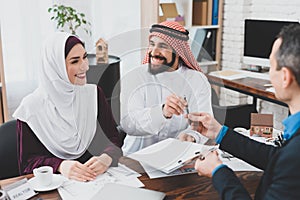 Realtor gives a pen to an Arab who must sign.