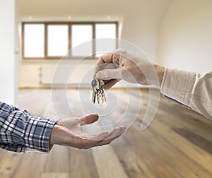 Realtor giving house key to buyer in loft room