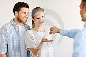 Realtor giving keys from new home to happy couple
