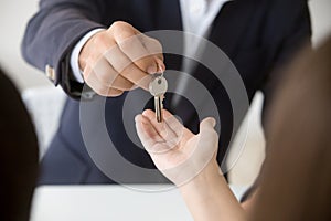 Realtor giving woman keys to new home, close up view