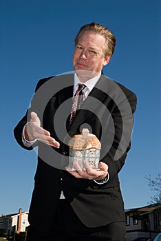 Realtor holding model house.