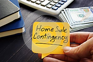 Realtor holds home sale contingency memo sign