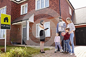 Realtor Outside House For Sale With Young Family